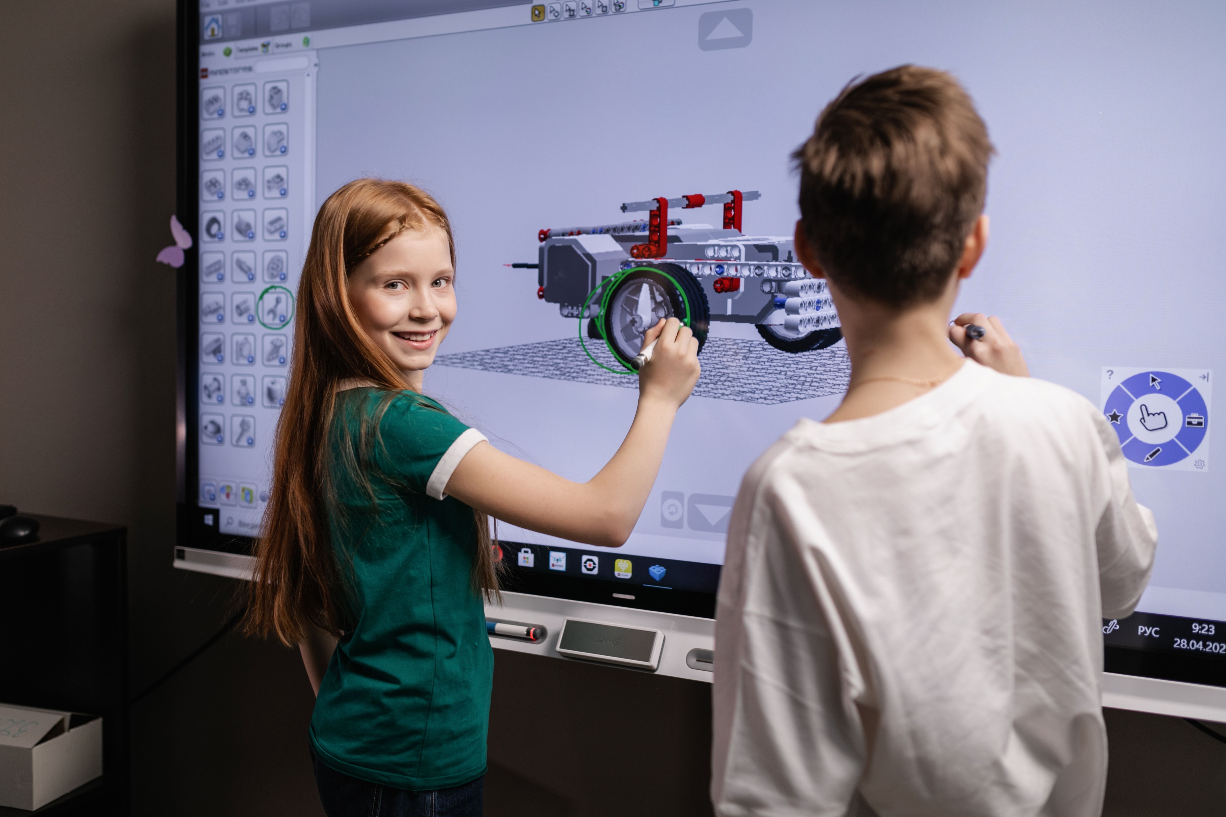 Zwei Lernende arbeiten gemeinsam an einem interaktiven Smartboard