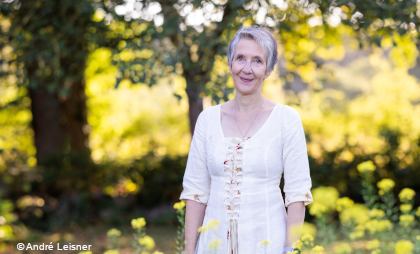 Foto von Lena Johannson  mit Bäumen und gelben Blüten im Hintergrund