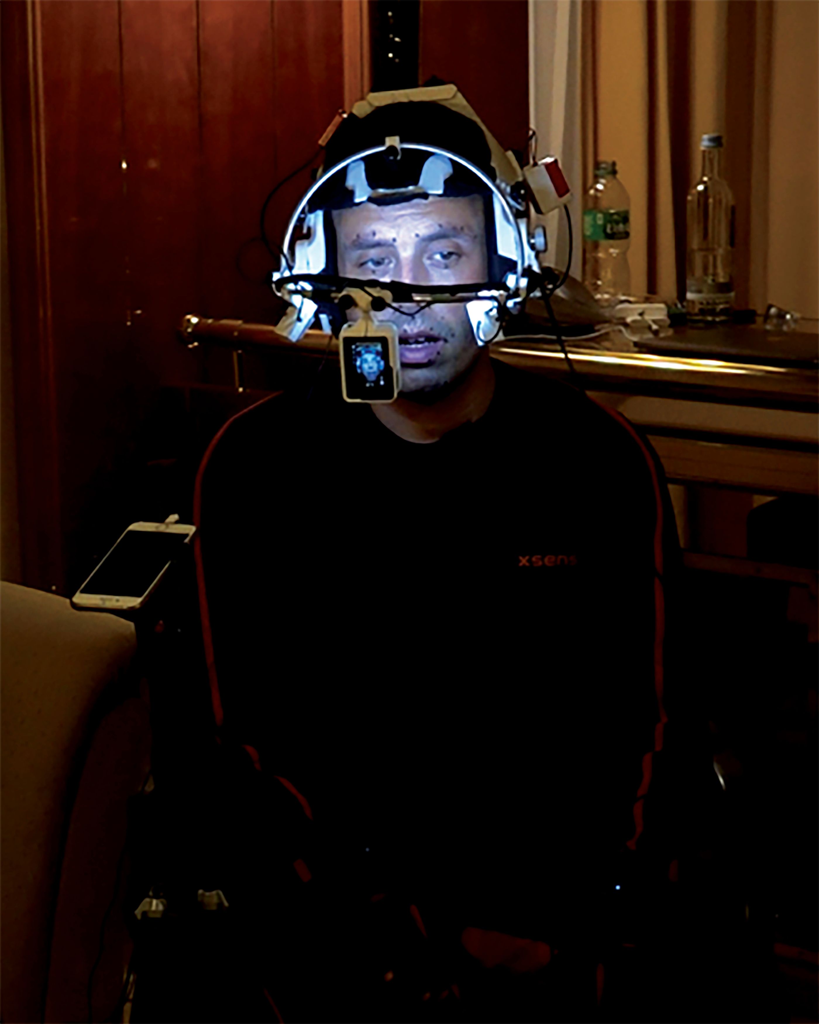 The artist rigged with performance capture equipment in a hotel room in Berlin in 2021, talking to his mother on the phone for his video work, The worm (2021) © Ed Atkins. Courtesy the artist