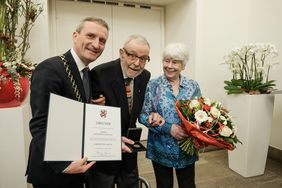 Oberbürgermeister Thomas Geisel überreichte die Verdienstplakette der Landeshauptstadt an Engelbert Oxenfort. Blumen gab es für Ehefrau Hildegard Oxenfort; Foto: Gstettenbauer