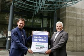 Sozialdezernent Stadtdirektor Burkhard Hintzsche (l.) und Amtsleiter Roland Buschhausen mit der Auszeichnung "Helden in der Krise", die das Düsseldorfer Amt für Soziales für das herausragende Engagement in der Corona-Krise erhalten hat.