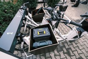 Foto von dem Transportkorb eines der E-Lastenräder in dem zwei Werkzeugboxen platziert sind.