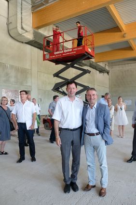 Oberbürgermeister Thomas Geisel (r.) und Stadtdirektor Burkhard Hintzsche stellten die Baufortschritte an der neuen Zweifachsporthalle in Wittlaer vor; Foto: Gstettenbauer