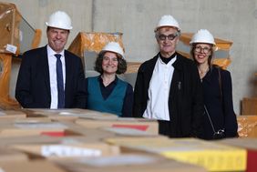 Auf der Baustelle des Wim-Wenders-Gymnasiums (v.l.n.r.): Oberbürgermeister Dr. Stephan Keller, Schulleiterin Dr. Antonietta Zeoli, Wim Wenders und seine Frau Donata Wenders.