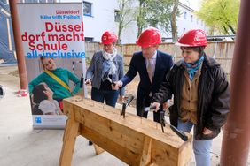 Dagmar Wandt (l.), Leiterin des Schulverwaltungsamtes, OB Thomas Geisel und Schulleiterin Corinna Lowin schlugen symbolisch den letzten Nagel am Rohbau ein; Foto: Gstettenbauer