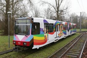 Auf der Bahn sind außen unterschiedliche Menschen in diversen Konstellationen grafisch dargestellt. 