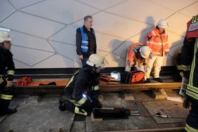 Ein Feuerwehrmann betätigt den hydraulischen Heber und hievt die Bahn einige Zentimeter nach oben. Das reicht aus, um die eingeklemmte Person zu befreien.