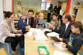 Kinder der Kita Am Walbert packen die neuen Tablets aus mit (v.l.) Ilka-Nadine Mielke, "real", Stadtdirektor Burkhard Hintzsche und Jugendamtsleiter Johannes Horn (rechts). Foto: Ingo Lammert