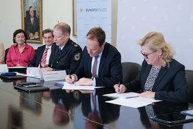 OB Dr. Stephan Keller (2.v.r.), Miriam Brauns (Polizeipräsidentin, r.) und Helge Scharfscheer (Vizepräsident Bundespolizeidirektion, 3.v.l.) unterschreiben den Kooperationsvertrag. Im Hintergrund: Miriam Koch und Christian Zaum. Foto: Gstettenbauer