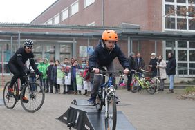 Sven Teutenberg und ein Schüler der Hulda-Pankok-Gesamtschule geben auf einem Hindernisparcours einen Vorgeschmack auf den Petit Départ. Foto: Ingo Lammert