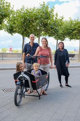 Umweltdezernentin Helga Stulgies (re.) überreichte der Familie Holger, Nina, Emma (6) und Lasse (2) Thomas den Preis für ihren Siegerbeitrag bei der Klimachallenge des Umweltamtes - ein E-Lastenfahrrad. Foto: Michael Gstettenbauer