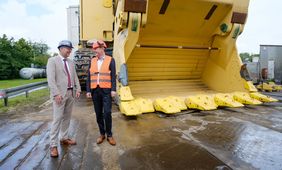 Oberbürgermeister Dr. Stephan Keller (r.) mit Komatsu-Geschäftsführer Ansgar Thole vor der Schaufel des größten Hydraulikbaggers der Welt. Foto: Michael Gstettenbauer