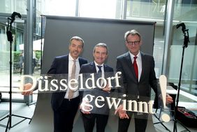 Marc Ufer, Regionalvorstand West KPMG AG Wirtschaftsprüfungsgesellschaft, Oberbürgermeister Thomas Geisel und Michael Grütering, Hauptgeschäftsführer Unternehmerschaft Düsseldorf und Umgebung e.V. (von rechts), mit dem 'Düsseldorf gewinnt'-Logo