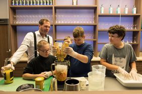Die Klasse 6b der Gemeinschaftshauptschule Bernburger Straße kreierte im Meliá-Hotel mit Unterstützung von Bar-Manager Markus Sahm gesunde Köstlichkeiten für den guten Zweck, Foto: Uwe Schaffmeister.