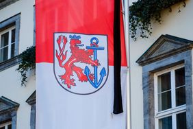 Die Flaggen am Düsseldorfer Rathaus tragen Trauerflor. Foto: Gstettenbauer