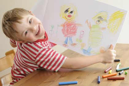 Junge mit Down-Syndrom zeigt seine Zeichnung, ©EVAfotografie, istock
