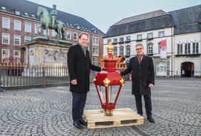 Oberbürgermeister Dr. Stephan Keller (l.) und Torben Beisch, Geschäftsführer der Netzgesellschaft, mit einer der vier frisch restaurierten Leuchten. Foto: Melanie Zanin