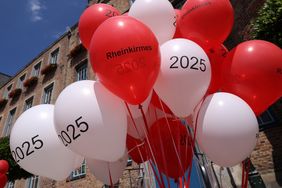Rot-weiße Luftballons stimmten beim Medientermin auf die Rheinkirmes 2025 ein. Foto: David Young