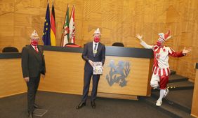 (v. r.) Hoppeditz Tom Bauer, Oberbürgermeister Dr. Stephan Keller (mit Narrenspiegel) und Michael Laumen, Präsident Comitee Düsseldorfer Karneval im Plenarsaal