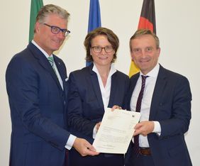 Land NRWDüsseldorfs Oberbürgermeister Thomas Geisel (rechts) und Dezernent Prof. Dr. Andreas Meyer-Falcke nehmen den Förderbescheid von NRW-Kommunalministerin Ina Scharrenbach entgegen, Foto: Land NRW.