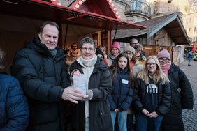 Oberbürgermeister Dr. Stephan Keller mit Trauerbegleiterin Sylvia Schleuter und betroffenen Familien (v.l.) bei der Auftaktaktion am 30. November vor der neuen Weihnachtshütte für das Ehrenamt.