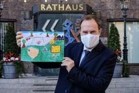 Oberbürgermeister Dr. Stephan Keller präsentiert eins der eingereichten Kunstwerke für den Kinder- und Jugendmalwettberb von "Mayors for Peace". Foto: Michael Gstettenbauer