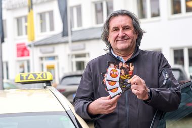Taxifahrer Marek Grolik mit den Kondom-Karten des Gesundheitsamtes: 5.000 Kondome werden während der "tollen Tage" im Auftrag des Gesundheitsamtes von Düsseldorfer Taxifahrerinnen und Taxifahrern an ihre Kundschaft verteilt. Foto: LHD/Claus Langer