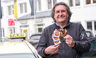 Taxifahrer Marek Grolik mit den Kondom-Karten des Gesundheitsamtes: 5.000 Kondome werden während der "tollen Tage" im Auftrag des Gesundheitsamtes von Düsseldorfer Taxifahrerinnen und Taxifahrern an ihre Kundschaft verteilt. Foto: LHD/Claus Langer