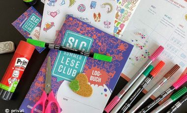 Foto mit dem SommerLeseClub Leselogbuch und Bastelmaterialien und Stickern.
