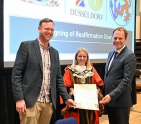 Die Oberbürgermeisterin von Reading, Rachel Eden, und Readings Ratsvorsitzender Jason Brock (l.) unterzeichneten in einer Beteuerungszeremonie erneut eine Städtefreundschaftsurkunde und übergaben sie an OB Keller; Foto: Forsey