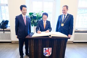 Toshihito Kumagai (l.), Gouverneur von Chiba, und Masahiro Ito, Vorsitzender des Präfekturparlaments, haben sich im Beisein von OB Dr. Keller in das Goldene Buch der Stadt eingetragen. Foto: Gstettenbauer