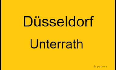 Textgrafik, die aussieht, wie ein Ortseingangsschild: Düsseldorf Unterrath, schwarze Schrift auf gelben Grund