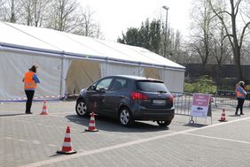 Menschen fahren mit ihren Fahrzeugen zum Abstrich in den Zelten an der Veranstaltungshalle an der Siegburger Straße. Foto: Ingo Lammert