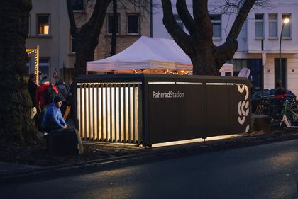 Überdachte Fahrradstation der Mobilitätsstation Hermannplatz, hell erleuchtet am Abend