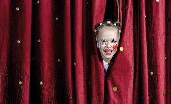 Foto von eines Kindes, das den Kopf durch einen Bühnenverhang steckt