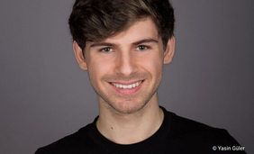 Porträtfoto eines jungen Mannes, der in die Kamera lächelt