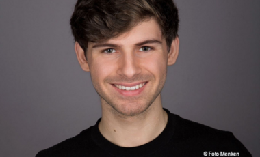 Porträtfoto eines jungen Mannes, der in die Kamera lächelt