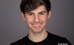 Porträtfoto eines jungen Mannes, der in die Kamera lächelt