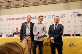 Tour-Direktor Christian Prudhomme, Moderator Aljoscha Höhn und OB Thomas Geisel bei der großen Kinder-PK mit deutschen Radsportstars. Foto: Michael Gstettenbauer