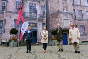 (v.l.) OB Thomas Geisel, Dr. Henrike Schwarz, Dr. Dietmar F. Seitz und Nadin Willfahrt - im Hintergrund das Rathaus mit rosafarbener Schleife
