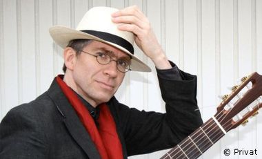 Foto von Jochen Jasner mit Hut und Gitarre
