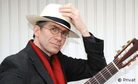Foto von Jochen Jasner mit Hut und Gitarre