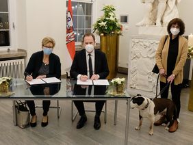 Vertragsunterzeichnung im Jan-Wellem-Saal: Oberbürgermeister Dr. Stephan Keller mit Monika Piasetzky, Vorsitzende Tierschutzverein Düsseldorf, und der stellvertretenden Vorsitzenden Wilfriede Bürger - und dem Hund "Pascha"; Foto: Meyer 