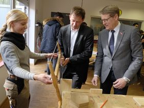Thomas Dopheide (r.), Obermeister der Tischler-Innung Düsseldorf, schaut genau hin, wie Stadtdirektor Burkhard Hintzsche bei der Ausbildungsmesse die Säge bedient; Foto: Meyer