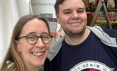 Eine Frau und ein Mann lächeln in die Kamera