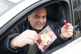 Taxifahrer Kamanli Cumhur mit Kondom-Postkarte und "Roter Schleife". Foto: David Young