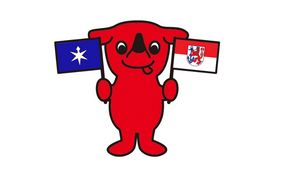 Chiba-kun, das Maskottchen der Stadt Chiba, das die Fahnen der beiden Städte Düsseldorf und Chiba hoch hält