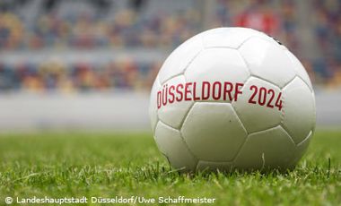 Foto vom Fußball auf Rasen mit der Aufschrift: Düsseldorf 2024