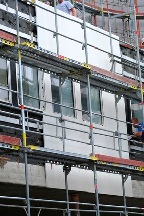 Die Fassadenarbeiten haben bereits an der Gebäudeseite zum Gustaf-Gründgens-Platz hin begonnen, sodass dort die ersten neuen Fassadenbleche zu sehen sind; Foto: Michael Gstettenbauer