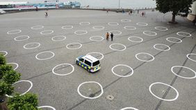 Weiße Kreise auf dem Burgplatz sollen die Menschen an den gebotenen Abstand zum Schutz vor der Ansteckung mit dem Coronavirus aufmerksam machen. Foto: David Young